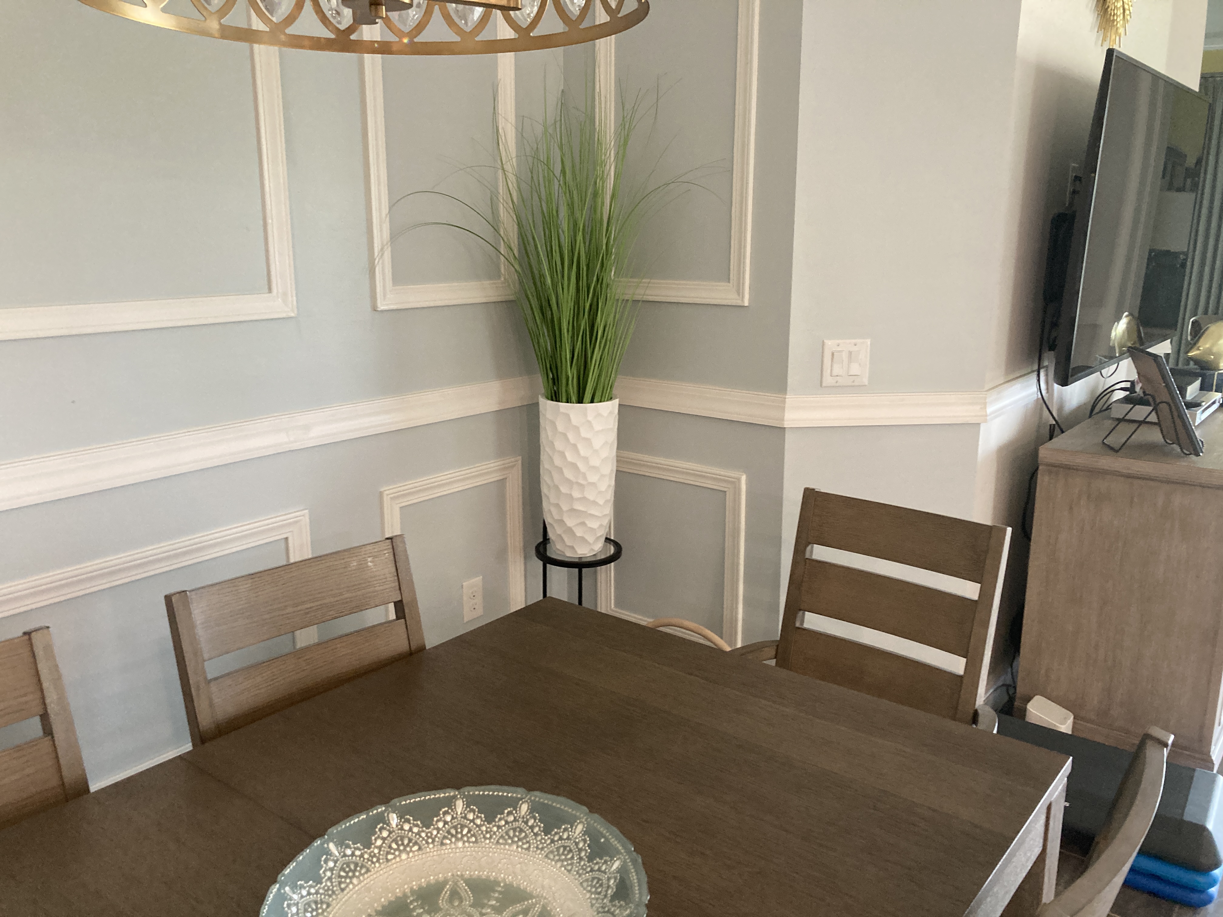 Full dining room view with wainscoting, chandelier, and dining table